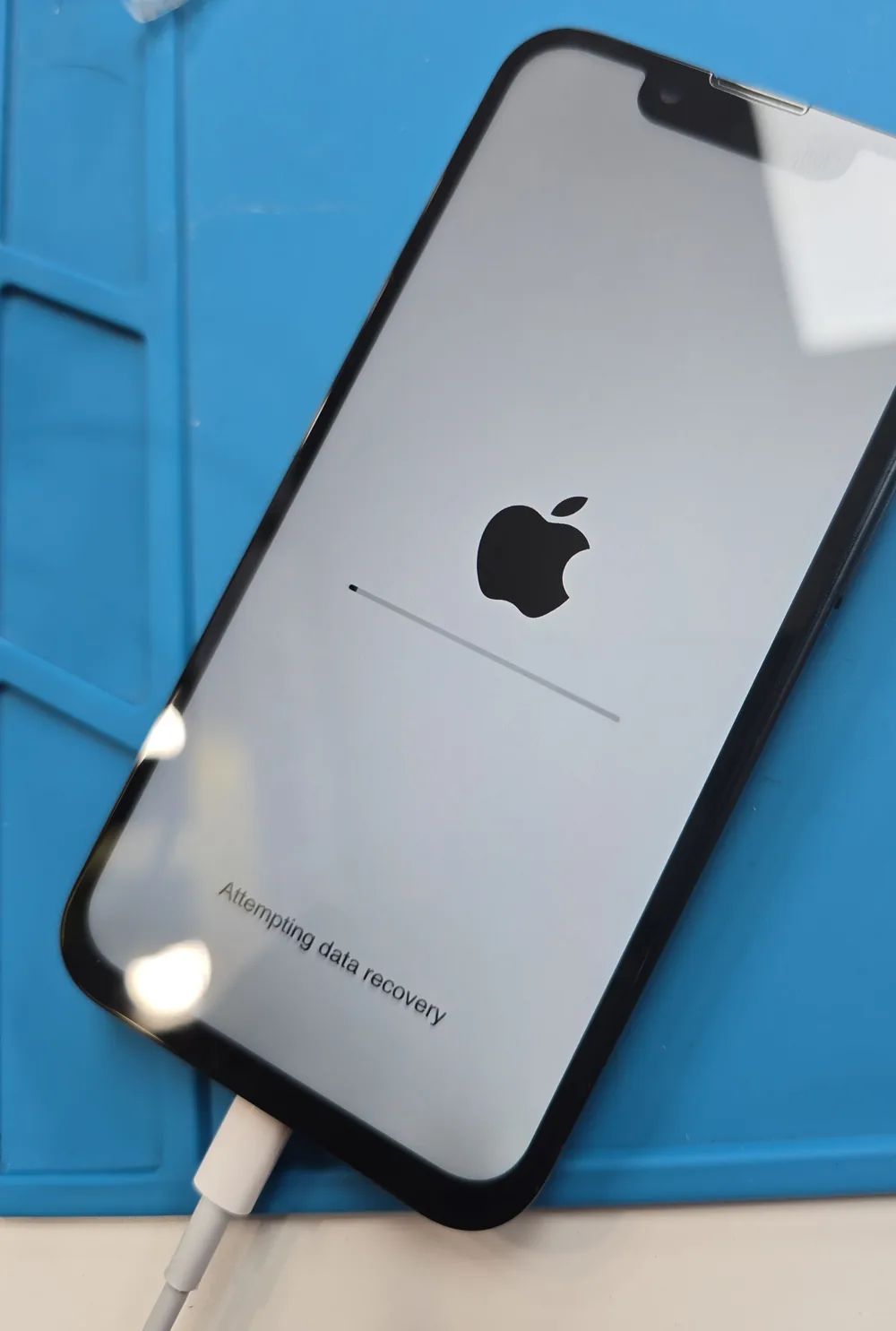 iPhone 13 Pro Max on the Phone Studio bench in Courtice showing the Apple logo and an “Attempting data recovery” progress bar after board-level power-line repair