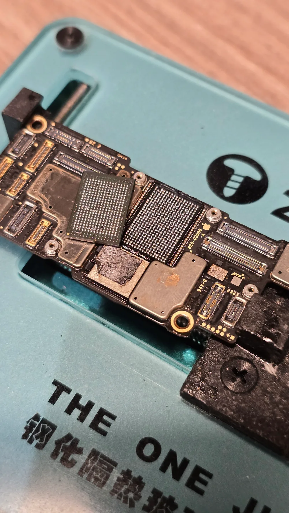 iPhone logic board with the NAND chip lifted off during board-level micro-soldering at the Phone Studio bench in Courtice